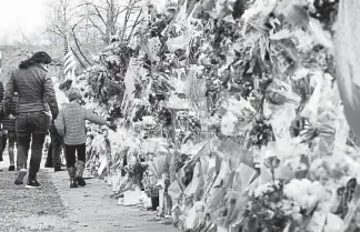  ?? Helen H. Richardson, The Denver Post ?? Jessica Benjamin and her son Mason, 5, look at all of the flowers in the memorial along the fence line outside of the Boulder Table Mesa Drive King Soopers on Thursday.