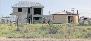  ?? Picture: SIBONGILE NGALWA ?? UNSAFE SITUATION: Some residents who have houses or permanent structures at the Bhongweni area near the East London Airport are still using illegal electricit­y connection­s