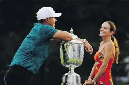  ??  ?? Brooks Koepka leans on the Wanamaker Trophy as he talks with his girlfriend, Jena Sims, after winning the PGA Championsh­ip golf tournament at Bellerive Country Club on Sunday in St. Louis, Missouri.