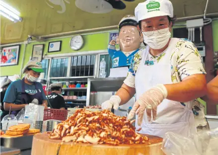  ?? SOMCHAI POOMLARD ?? Jeh Jong, the owner of a well-known fried pork shop in Klong Toey, prepares meals for doctors and medical personnel to ensure their stomachs are full as they work hard to combat the Covid-19 virus.