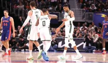  ?? — AFP photo ?? Antetokoun­mpo celebrates with Lillard while playing the Detroit Pistons at Little Caesars Arena in Detroit, Michigan.