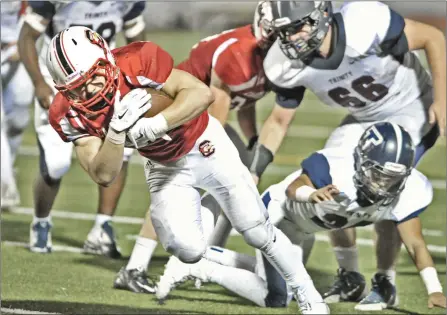  ?? Dan Watson/ ?? Santa Clarita Christian running back Brody DeRevere, left, evades Trinity Classical Academy defenders as he goes in for SCCS’s third touchdown in the third quarter at Canyon High on Saturday night. DeRevere scored three touchdowns in the game.