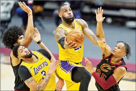  ??  ?? Los Angeles Lakers’ LeBron James drives to the basket against Cleveland Cavaliers’ Isaac Okoro (right), in the second half of an NBA basketball game, on Jan 25, in Cleveland. (AP)