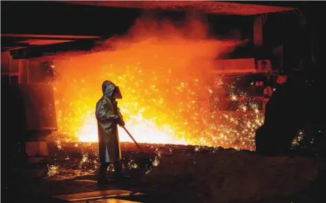  ?? — Reuters ?? An employee stands beside a blast furnace cast house at ThyssenKru­pp Steel USA factory in Calvert, Alabama.