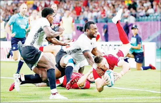  ??  ?? Wales’ Josh Adams scores a try during the Rugby World Cup Pool D game at Oita Stadium between Wales and Fiji in Oita, Japan on Oct 9.