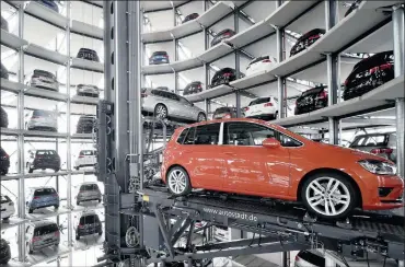  ?? PHOTO: REUTERS ?? A VW Golf VII is loaded in a delivery tower at Volkswagen’s plant in Wolfsburg. The German carmaker has shifted focus on the VW brand as it seeks to reduce reliance on the Audi and Porsche luxury marques for profit.