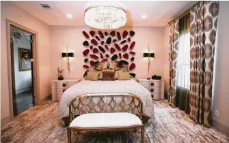  ??  ?? The bed in the master bedroom is by Christophe­r Guy and features a headboard of metalwork with soft orbs of deep red velvet.