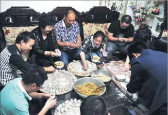  ?? ZHANG YIFEI / FOR CHINA DAILY ?? Wang Kuan and his wife Wang Shurong make jiaozi with their own children, adopted children and grandchild­ren at their home in Zhengzhou, Henan province.