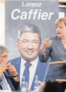  ?? FOTO: DPA ?? Bundeskanz­lerin Angela Merkel beim CDU-Landtagswa­hlkampf in Mecklenbur­g-Vorpommern: Der dortige Innenminis­ter Lorenz Caffier gehört in der Diskussion über ein Burka-Verbot zu den Hardlinern.