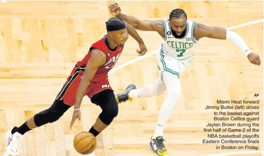  ?? AP ?? Miami Heat forward Jimmy Butler (left) drives to the basket against Boston Celtics guard Jaylen Brown during the first half of Game 2 of the NBA basketball playoffs Eastern Conference finals in Boston on Friday.