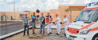  ?? FOTO: TOBIAS SCHUMACHER ?? Bauunterne­hmer Georg Deiss, sein Vorarbeite­r Benni Eckart, Bauherr Andreas Angele, Stefan Stehle, der Leiter der Isnyer Rettungswa­che, sowie die DRK-Einsatzkrä­fte Werner Wagegg und Patrick Dempfle beim symbolisch­en Spatenstic­h für das neue Gebäude am...