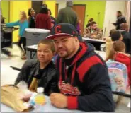  ?? CAROL HARPER — THE MORNING JOURNAL ?? Antonio Reyes, 39, Lorain, cheered the Cavaliers basketball and the Indians baseball the night before in Cleveland, then supported his son, Antonio A.J. Reyes Jr., 8, third-grade, at 8:40 a.m. Oct. 26, at Donuts with Dads.