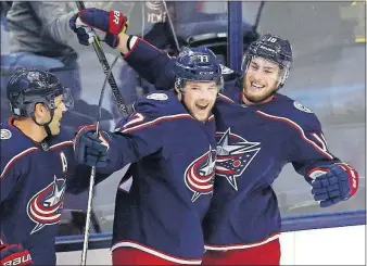  ?? [FRED SQUILLANTE/DISPATCH] ?? The Blue Jackets’ Josh Anderson, center, hugs Pierre-Luc Dubois after scoring on a Dubois assist less than two minutes into Tuesday’s game against Carolina.