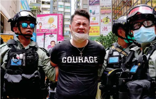  ??  ?? Téméraire. Hongkong, quartier de Causeway Bay, le 1er juillet. Arrestatio­n d’un manifestan­t contre la loi sur la sécurité nationale.