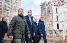  ?? ?? Ukrainian President Volodymyr Zelenskyy (left) and Greek Prime Minister Kyriakos Mitsotakis (second left) walk in front of a damaged residentia­l building at a site hit in a Russian drone attack on March 2, 2024, in Odesa, Ukraine, on March 6, 2024.