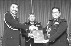  ??  ?? Asri (centre) witnessing the handing over ceremony between Ramli (left) and Omar at the police headquarte­rs in Kepayan yesterday. - Bernama photo