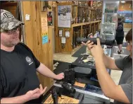  ?? (Arkansas Democrat-Gazette/Bryan Hendricks) ?? Josh Hunter demonstrat­es a SightMark thermal device to a customer at Fort Thompson Sporting Goods in Sherwood.