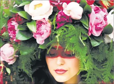  ?? DYLAN MARTINEZ / REUTERS ?? A model wears a floral headdress at the Royal Horticultu­ral Society's Chelsea Flower Show in London during the opening of the annual event on Monday.