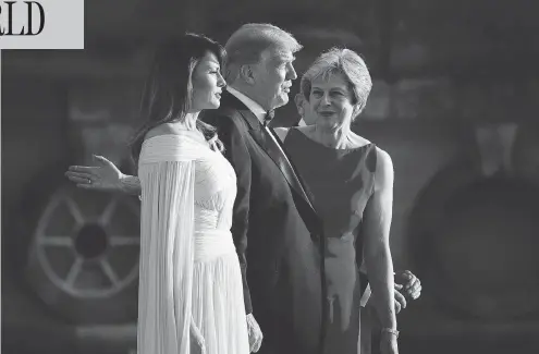  ?? BRENDAN SMIALOWSKI / AFP / GETTY IMAGES ?? British Prime Minister Theresa May, right, guides her guests Melania and Donald Trump before a black-tie dinner with business leaders at Blenheim Palace, west of London, on Thursday, the first day of the U.S. president’s four-day visit to the U.K. that...