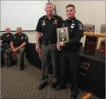  ?? JEN SAMUEL — MEDIANEWS GROUP ?? Police Officer Riley Miller receives the 2021Commis­sioners Award from Southern Chester County Police Department Chief Gerald Simpson at the New Garden Township municipal building on Thursday.