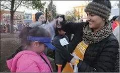  ??  ?? Kimberly Torres gets a squirt of colored hair spray courtesy of Jessica Mounce, a teacher at Elmdale Elementary in Springdale, before Kimberly took part in the 2016 Girls on the Run 5K run in downtown Bentonvill­e.
(NWA Democrat-Gazette file photo/Flip Putthoff)