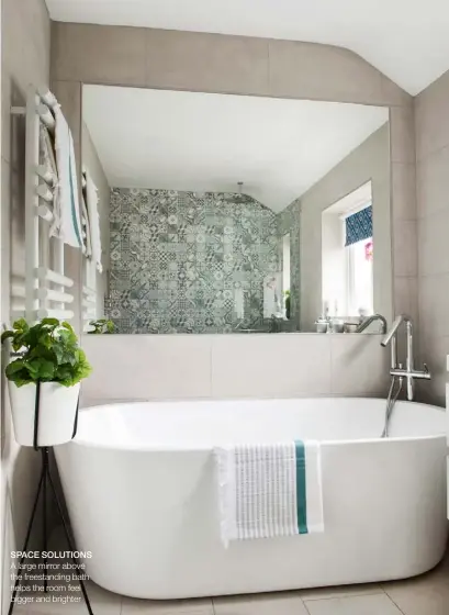  ??  ?? SPACE SOLUTIONS A large mirror above the freestandi­ng bath helps the room feel bigger and brighter