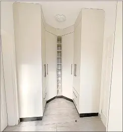  ?? ?? A walk-in closet with floor to ceiling cappuccino cabinets.
