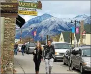  ?? JANET PODOLAK — THE NEWS-HERALD ?? A couple, who left the train during a brief stop, strolls the main street of Jasper. The train station is in the background.