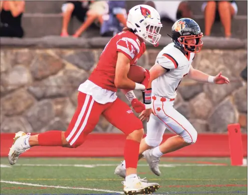  ?? Christian Abraham / Hearst Connecticu­t Media ?? Greenwich’s James Wailgum (2) carries the ball into the endzone for a touchdown against Ridgefield on Saturday.