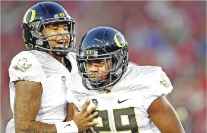  ??  ?? PALO ALTO: Vernon Adams Jr. #3 congratula­tes Kani Benoit #29 of the Oregon Ducks after he scored a touchdown in the first quarter of their game against the Stanford Cardinal at Stanford Stadium on Saturday in Palo Alto, California. — AFP