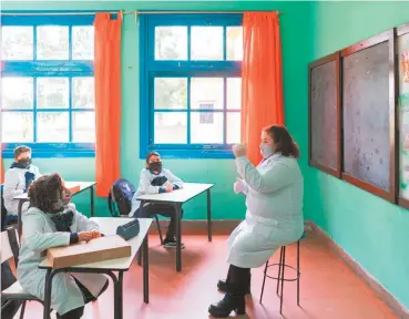  ??  ?? 2. Los niños ponen atención a la clase mientras la maestra habla de tapabocas y guantes en una escuela rural cerca de Empalme Olmos, Uruguay, junio 2 de 2020. Foto de Matilde Campodónic­o. 2 .