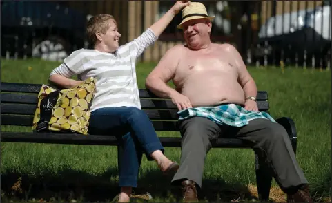  ??  ?? Rab Jardine and partner Sheila enjoy some rays of sunshine in Glasgow Green as temperatur­es soar across Scotland