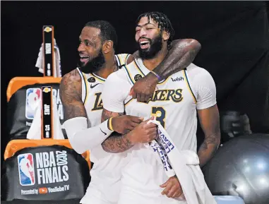  ?? MARK J. TERRILL/AP ?? LeBron James and Anthony Davis celebrate after the Lakers’ title-clinching win on Oct. 11.