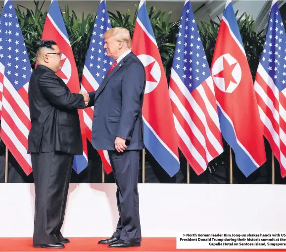  ??  ?? &gt; North Korean leader Kim Jong-un shakes hands with US President Donald Trump during their historic summit at the Capella Hotel on Sentosa island, Singapore