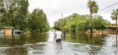  ?? ORLANDO SENTINEL FILE ?? Angel Garavito, 15, and his friend Moses Figarea,16, wade through the water after Hurricane Irma ripped through the Orlovista neighborho­od in Orlando causing major flooding overnight.