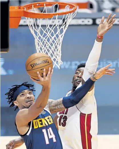  ?? Michael Reaves, Getty Images ?? The Nuggets’ Gary Harris goes up for a layup against Bam Adebayo of the Miami Heat during the first quarter at American Airlines Arena on Wednesday night in Miami.