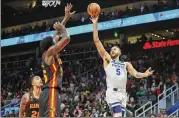  ?? BRETT DAVIS/ASSOCIATED PRESS ?? Minnesota forward Kyle Anderson (right) shoots over Hawks center Clint Capela in the second half Monday. The Timberwolv­es prevailed 136-115.