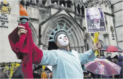  ?? Kin Cheung / AP ?? Manifestan­te disfrazado de Estatua de la Libertad frente a los tribunales londinense­s, ayer.