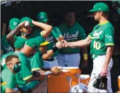  ??  ?? The Athletics’ starter Chris Bassitt, right, pumps fists with teammates after he was pulled in the eighth inning.