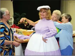  ?? Contribute­d Photo ?? Mrs. Potts gets ready: Members of the South Arkansas Arts Center’s Costume Committee, from left, Delaine Gates, Sherry Bradfute, Pam Bosanko and Mary Eggerer, prepare Mrs. Pott’s costume for the upcoming production of the arts center’s ‘Disney’s Beauty...