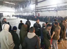  ?? — Reuters ?? Migrants wait for food in a migrant camp in Bihac on Friday.