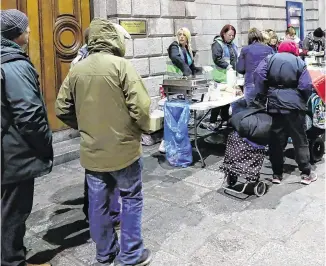  ?? PHOTO: NIALL CARSON/PA WIRE ?? Hard times: Families at The Lending Hand, a soup kitchen feeding up to 300 people every Monday on College Green, Dublin.