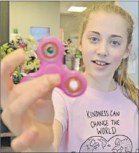  ?? DESIREE ANSTEY/ JOURNAL PIONEER ?? Fidget spinners are the latest kid craze. Jessica Robichaud, 12, of Summerside, owns a pink-coloured one. “It’s satisfying to watch,” she said.