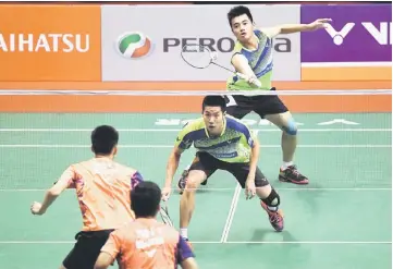  ??  ?? Malaysia’s Tan Wee Kiong hits a return as Goh V Shem looks on during their men’s doubles match against compatriot­s Ong Yew Sin and Teo Ee Yi. — Bernama photo