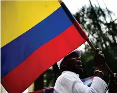  ??  ?? Un hombre ondea una bandera nacional en Cali para celebrar el acuerdo entre el gobierno y las FARC.