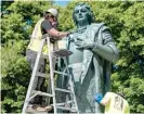  ?? TYLER LARIVIERE/SUN-TIMES ?? Workers with We Save Art clean paint Monday from a Christophe­r Columbus statue at 801 S. Loomis St.