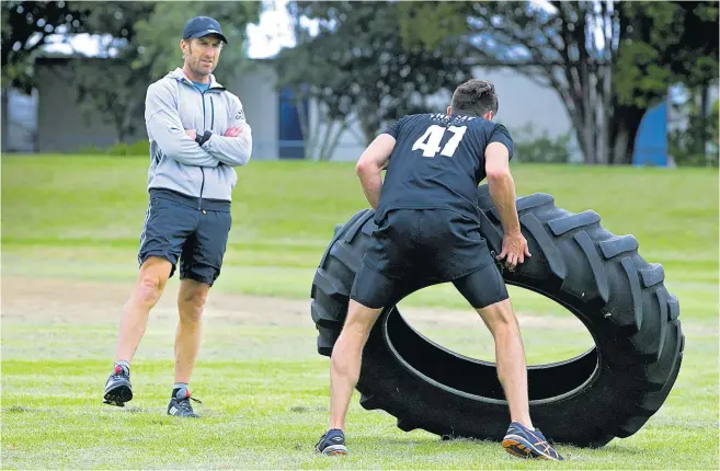  ?? Pictures / Alan Gibson ?? Journalist Liam Napier feels the burn under the watchful eye of Nic Gill during tyre flips and rope swings.