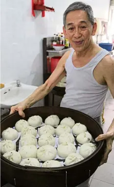  ??  ?? Bun-dles of joy:
Yau showing off the freshlymad­e steamed buns at his shop in Rantau.