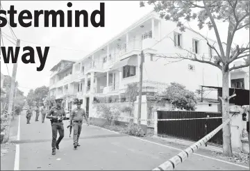  ??  ?? File photo shows Sri Lankan security forces walking past a house in Colombo where a raid occurred after a suicide blast. — AFP photo