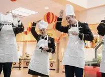  ?? ?? Lt. Col. Stephanie Wentz and Capt. Tad Black try on chef hats before serving food to soldiers Thursday.